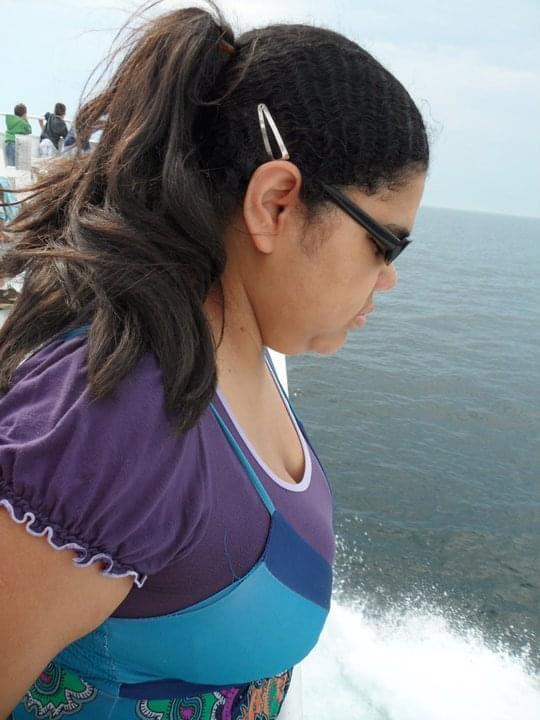 Fernanda Adriele Silva standing by sea side wearing black sunglasses after getting blind